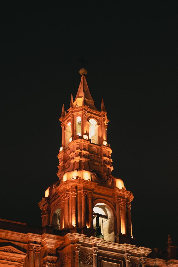A beautifully lit church tower in Arequipa, showcasing historic architecture at night.