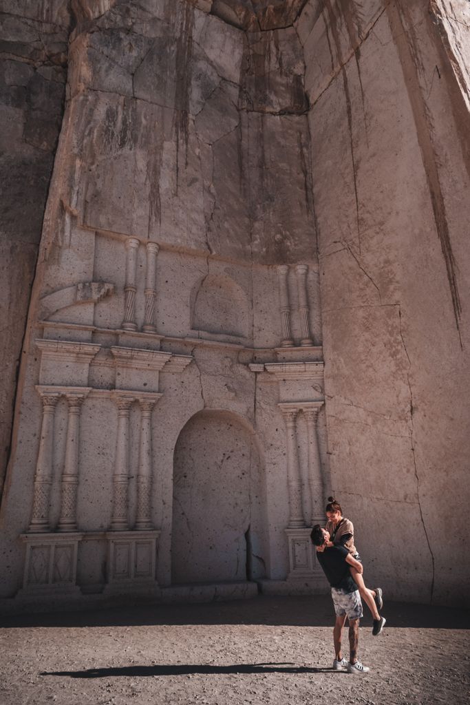 A couple shares a moment at the historic Sillar Quarry in Arequipa, Peru, under bright daylight.
